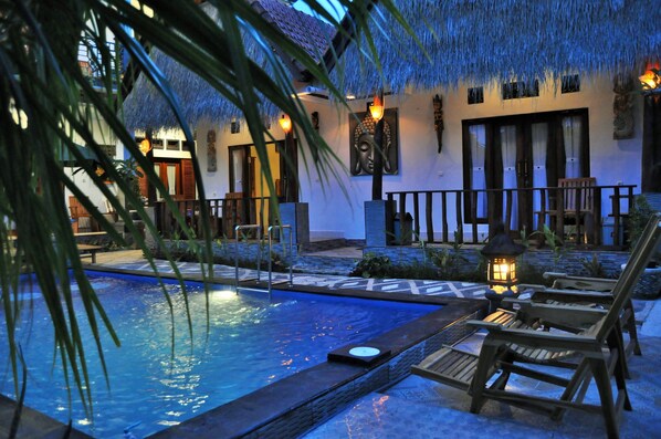 Een buitenzwembad en ligstoelen