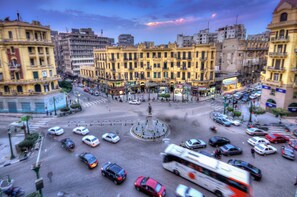 A busy urban intersection with multiple lanes of traffic, including cars, buses, and motorcycles.