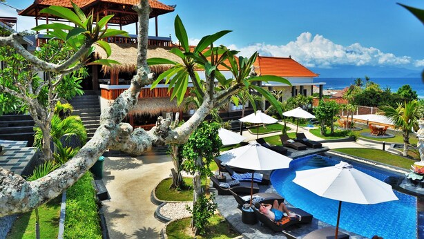 A resort with a pool area, lounge chairs, umbrellas, and a view of the ocean. - Pandawa Beach Resort and Spa Luxury (Penida Island)