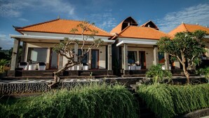 A modern building with a tiled roof, large windows, and a well-maintained garden. - Pandawa Beach Resort and Spa Luxury (Penida Island)