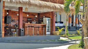 A restaurant with a wooden facade, a bar area, and a thatched roof. - Pandawa Beach Resort and Spa Luxury (Penida Island)