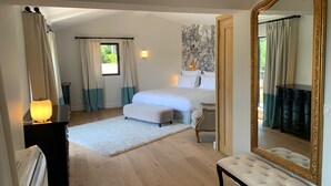 A bedroom with a large bed, a bedside table with a lamp, a bench, a dresser, and a large mirror. - Luxury, modern villa, 8min walking distance to town and beaches - heated pool (Sainte-Maxime)