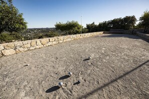 An outdoor area with a stone wall and a clear view of the surrounding landscape.