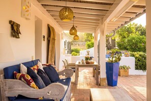 A covered outdoor seating area with a sofa, chairs, and a table. - Cozy family-friendly holiday home with many extras (Sao Bras de Alportel)