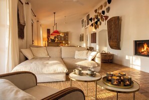 A cozy living room with a sofa, armchairs, a coffee table, and a fireplace.