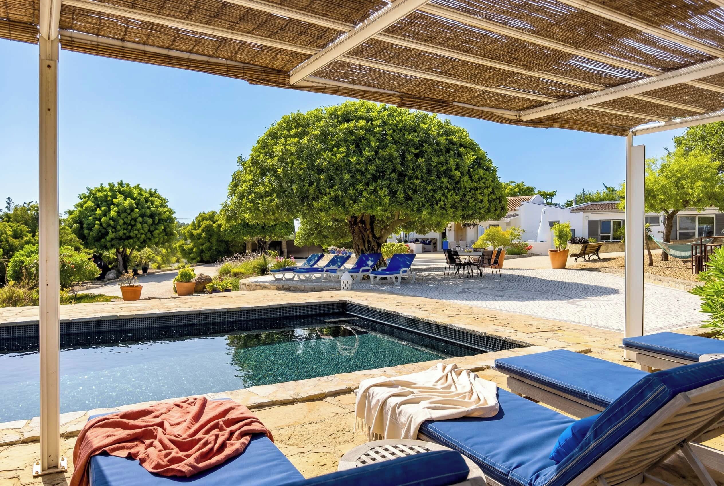 A pool area with lounge chairs and a pergola.