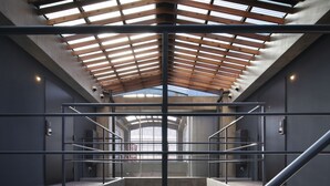 A modern interior with a skylight, metal railings, and a concrete floor. - So Kyoto Fushimi Inari (Kyoto)
