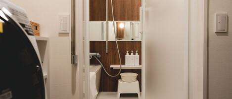 A compact bathroom with a shower, a toilet, and a sink.