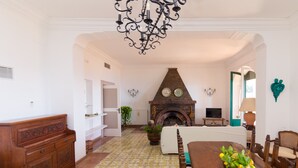 A room with a fireplace, a dining table, and a chandelier.