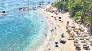 A beach with clear water, umbrellas, and people. - PENTHOUSE ANDALOU - NICE VIEW ON THE SEA (Benalmádena Costa)
