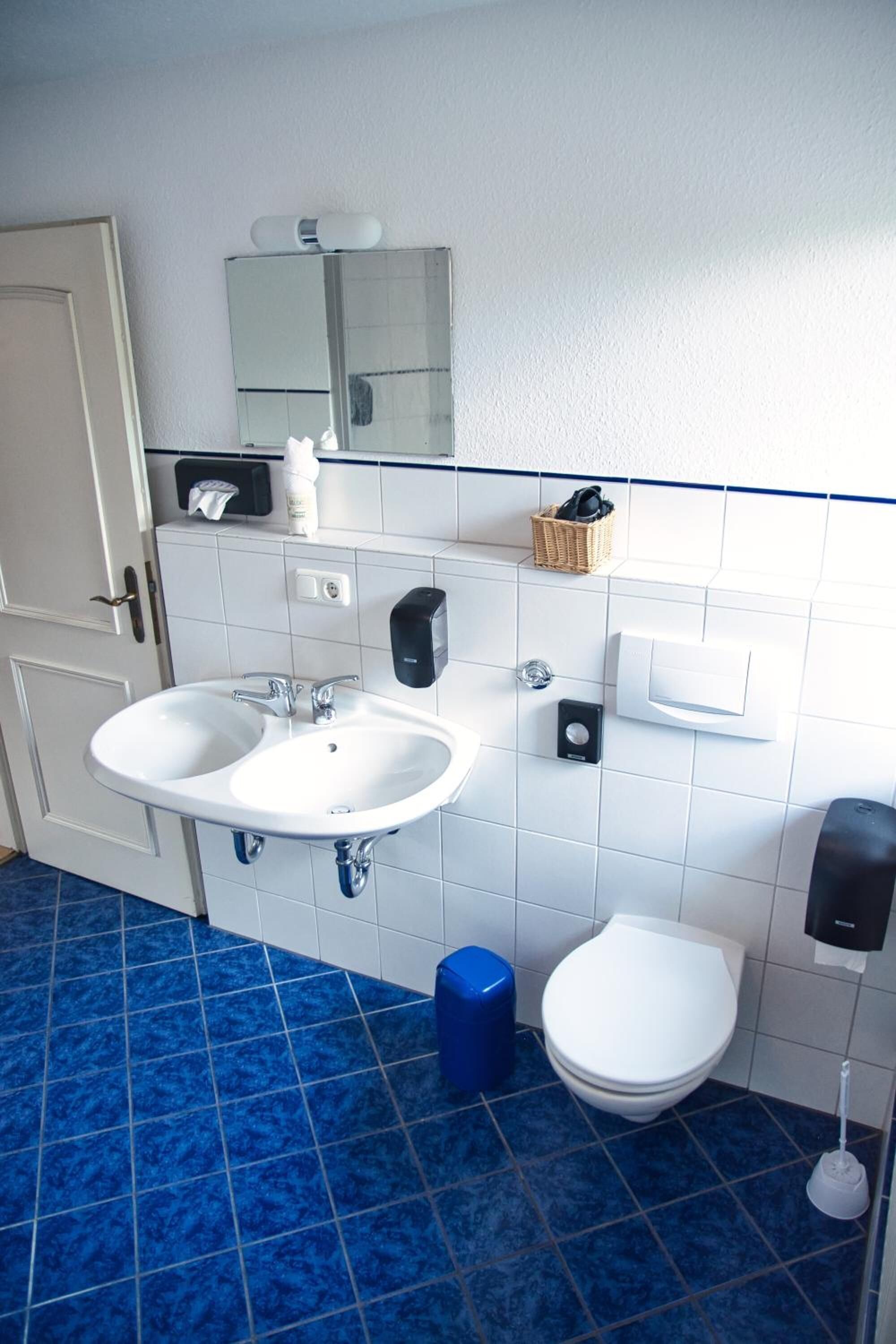 A bathroom with two sinks, a toilet, and a mirror.