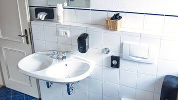 A bathroom with two sinks, a toilet, and a mirror.