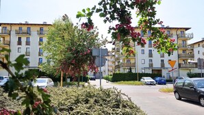 A residential building with multiple balconies, a parking area, and a sign indicating a nearby restaurant. - Bryza (CH18B) - CH18B (Swinoujscie)