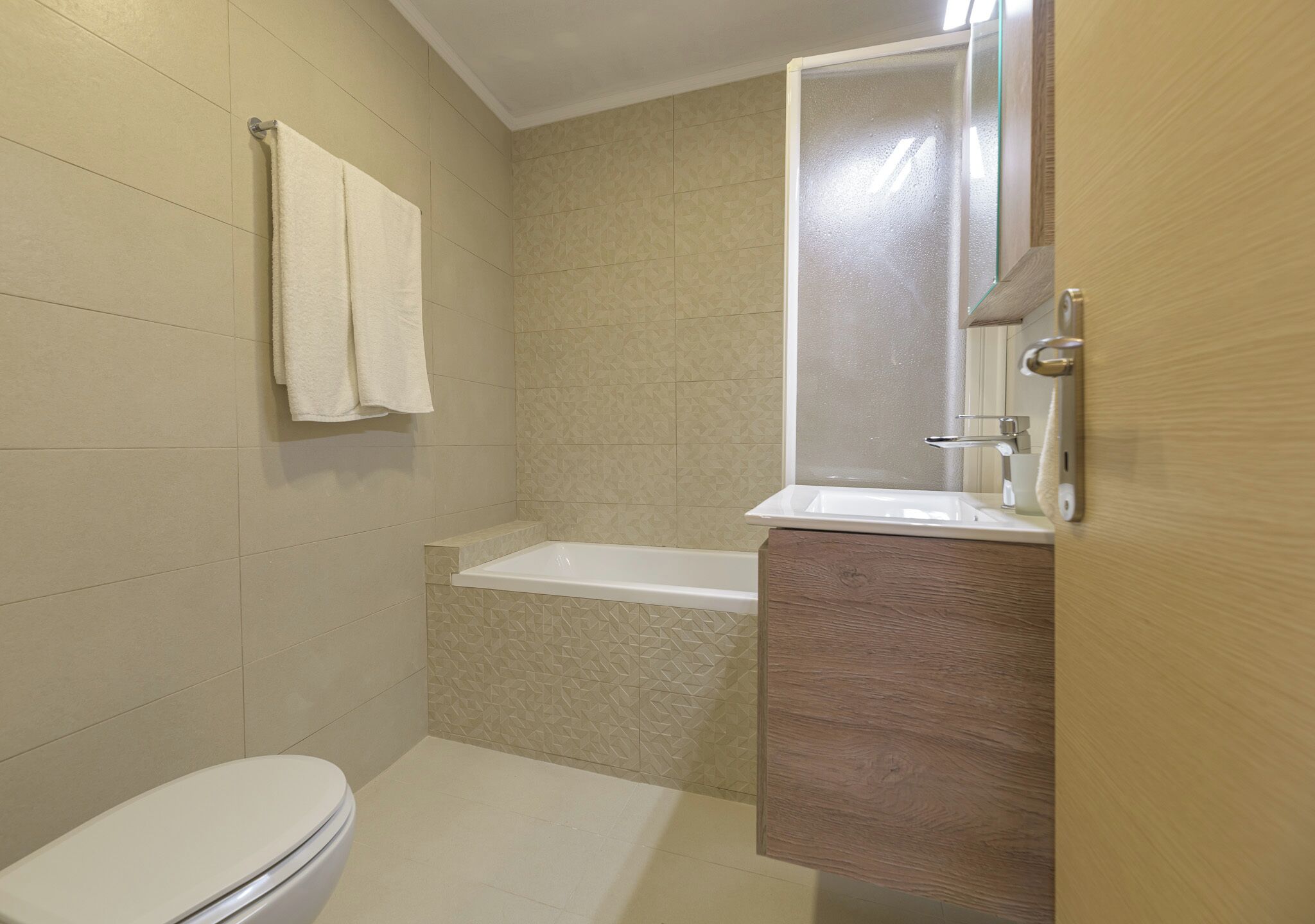 A bathroom with a toilet, a bathtub, and a sink.