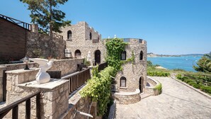 A stone building with arched windows and a view of the sea. - Harmony Hotel (Zakynthos)