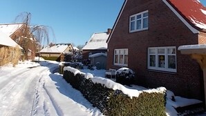 A residential street with snow-covered houses and a clear blue sky.