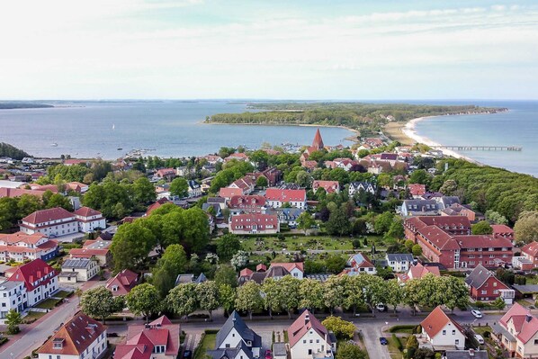 A coastal town with red-roofed houses, a prominent church spire, and a beach. - Apartment REFUGIUM RERIK - Apartment REFUGIUM RERIK (Rerik)