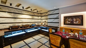 A hotel dining area with marble walls, a buffet setup, and a table with a 'RESERVED' sign. - La-Sapphire Hotel (New Delhi)