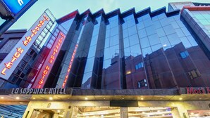 The exterior of the La Sapphire Hotel with reflective glass facade and illuminated signage. - La-Sapphire Hotel (New Delhi)