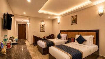 A hotel room with two beds, a marble countertop, a television, and a framed picture on the wall.