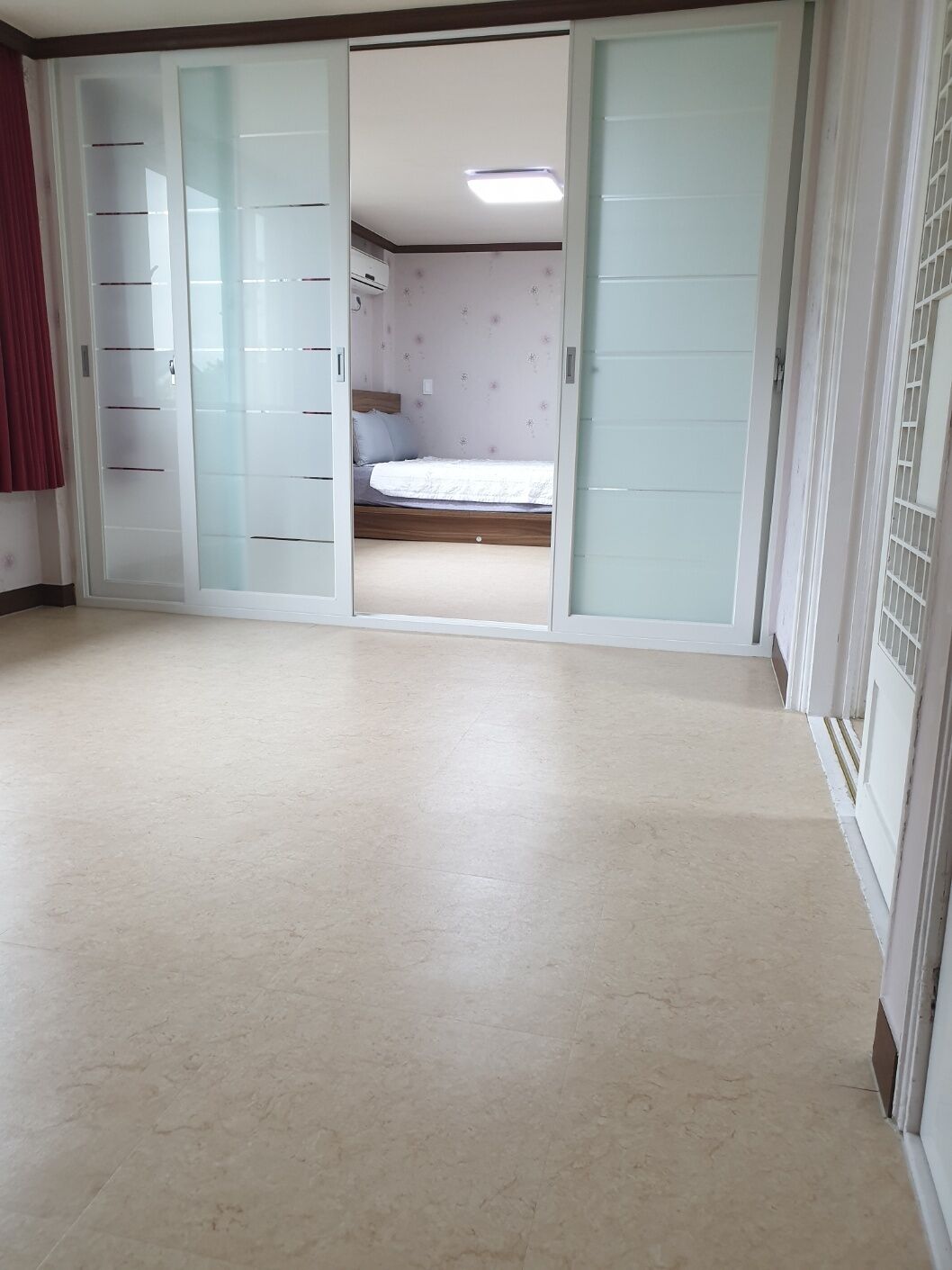 Ein Zimmer mit einem Bett, einem Kleiderschrank und einer Schiebetür.