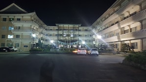 A multi-story hotel with balconies, a central courtyard, and a parking area. - Sajo Resort Gyeongju (Gyeongju)