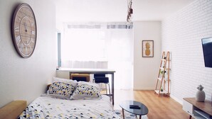 Een moderne slaapkamer met een bed, bureau en televisie.