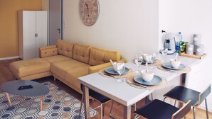 Een moderne woonkamer met een gele bank, een eettafel gedekt voor vier personen en een wandklok.