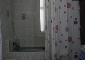 A bathroom with a shower, a window, and a curtain with a polka dot pattern. - Sweet home houmt souk Djerba (Djerba)