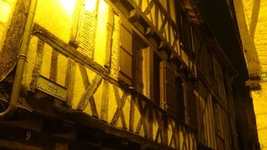 Un bâtiment traditionnel à colombages, avec des poutres en bois apparentes et une enseigne indiquant « Rue Saint-Clair ».