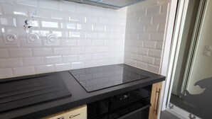 A kitchen with white subway tiles, a black countertop, and a dishwasher. - Cozy studio with Wifi near slopes in Tignes (Tignes)