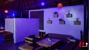A cozy lounge area with wooden furniture and potted plants on the wall. - Zebra Boutique Hotel (Kigali)