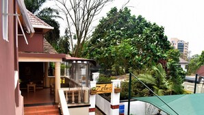 A hotel entrance with a covered outdoor seating area, a staircase leading to the entrance, and a sign with the hotel's name. - Zebra Boutique Hotel (Kigali)