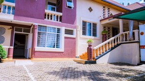 A two-story building with a reception area, a staircase, and a paved entrance. - Zebra Boutique Hotel (Kigali)