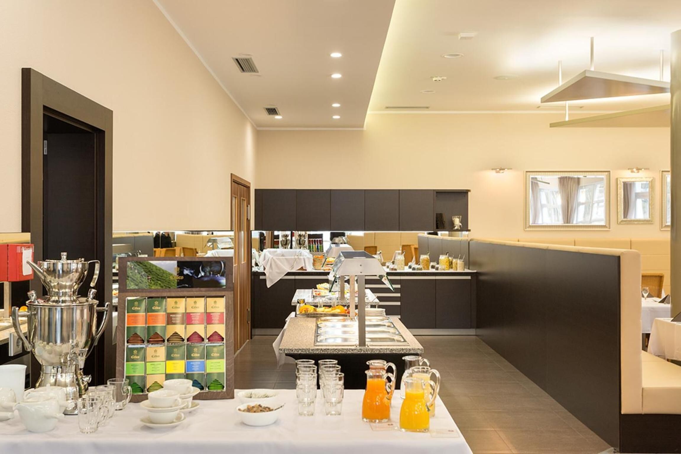 A buffet setup with various food items and beverages, a coffee station, and seating areas.