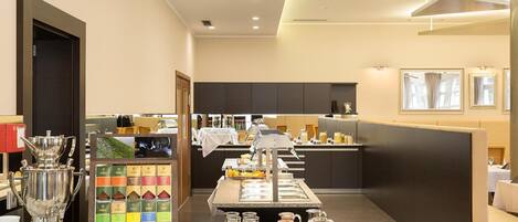 A buffet setup with various food items and beverages, a coffee station, and seating areas.