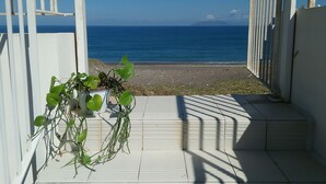 A view of the ocean through a white gate, with a potted plant on the steps. - La Foresteria di Maestina (Barcellona Pozzo di Gotto)