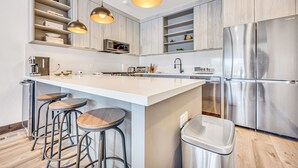 A modern kitchen with a large island, stainless steel appliances, and pendant lighting. - Best Location Ski Pad in Deer Valley! Right on free shuttle route! Sleeps 16! (Deer Valley)