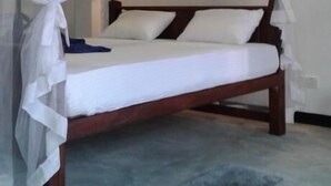 A bed with a wooden frame and white bedding, covered by a white canopy. - Sea Glow -Tangalle (Tangalle)