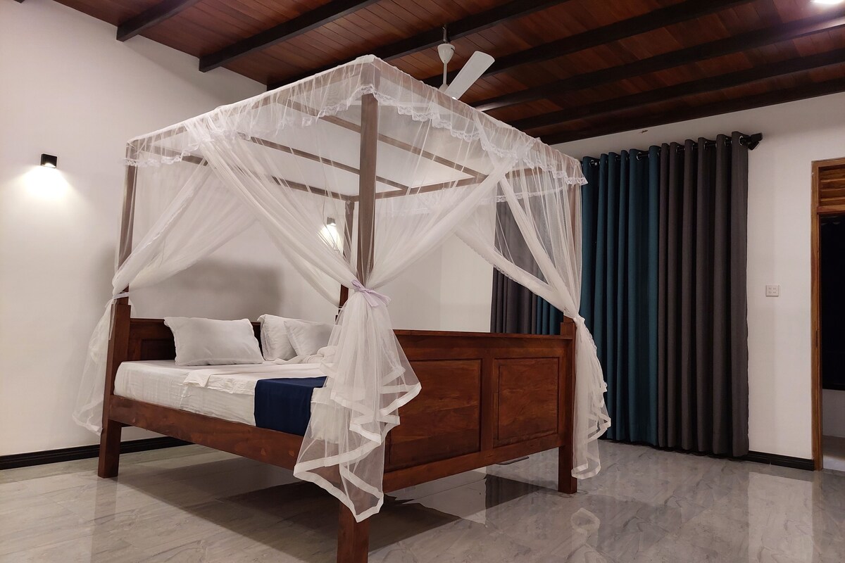 Una cama con dosel y estructura de madera, con ropa de cama blanca.