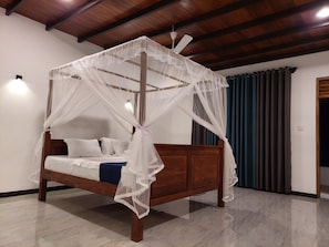 Una cama con dosel y estructura de madera, con ropa de cama blanca.