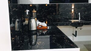 A modern kitchen with black marble countertops, stainless steel appliances, and a white sink. - Sea Glow -Tangalle (Tangalle)