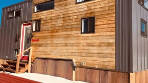 Een modern gebouw met een houten gevel en een rood dak.