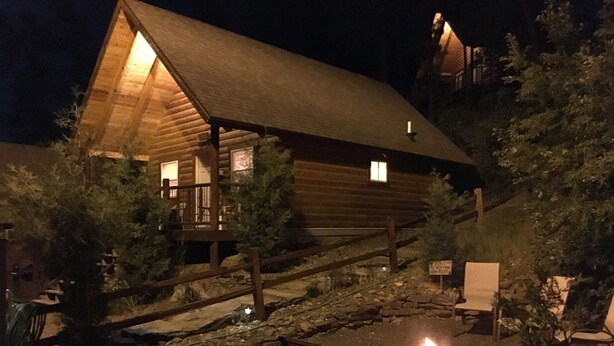 Una cabana de fusta amb una fosa i seients exteriors.