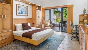 A bedroom with a large bed, wooden wardrobe, and a balcony with outdoor furniture. - Ocean Front Condo at The Royal Sea-Cliff Resort (Kailua Kona)