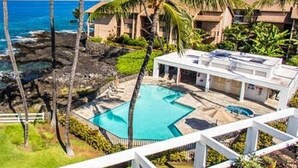 A resort with a pool, palm trees, and ocean views. - Ocean Front Condo at The Royal Sea-Cliff Resort (Kailua Kona)