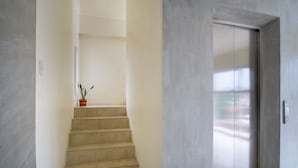 A modern interior with a staircase leading to an elevator. - 18 Suites Cebu (Cebu City)