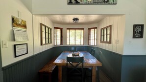A dining area with a wooden table and benches, a calendar, and a sign that reads "KITCHEN".