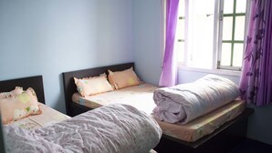 Una habitación con tres camas, cada una con un diseño de almohada distinto.