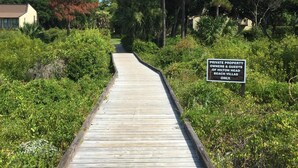 A wooden boardwalk leading to a private property with a sign indicating it's for owners and guests of Hilton Head Beach Villas only. - 3 Bedroom, 3 Bath Oceanside Beach Villa (Hilton Head Island)